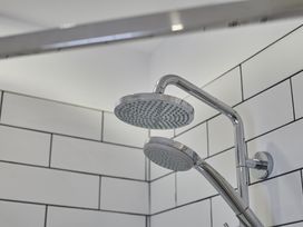 A shower head and wall tiles at Beachside Cottage in Sandsend