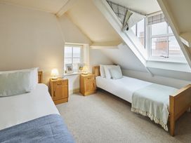 A bedroom with two beds and a window at Beachside Cottage in Sandsend