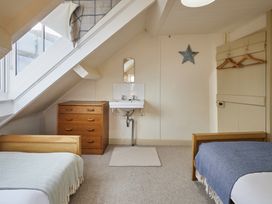 A bedroom with two beds and a sink at Beachside Cottage in Sandsend