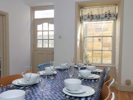 A dining room with a table set for meals at Beachside Cottage in Sandsend