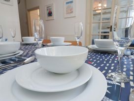 A dining table set with plates and glasses at Beachside Cottage in Sandsend