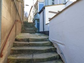 A stone staircase with a handrail and buildings on either side at Beachside Cottage in Sandsend