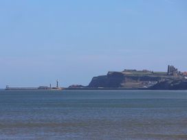 A view of a lighthouse and pier along the ocean at Beachside Cottage Sandsend