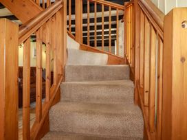 A carpeted staircase with wooden railings in a living area at Rock Cottage Portmellon near Mevagissey
