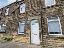 An exterior view of a house with stone walls and a door at Amblers Rest in Amble