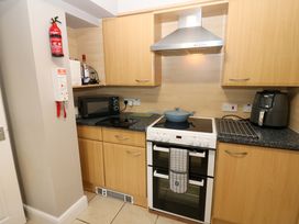 A kitchen with a stove, oven, microwave, and air fryer at Amblers Rest in Amble