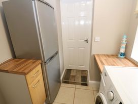 A kitchen with a refrigerator and washing machine at Amblers Rest in Amble
