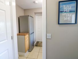 A kitchen area featuring a refrigerator and cabinet at Amblers Rest in Amble