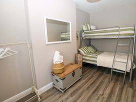 A bedroom with a bunk bed and a single bed at Amblers Rest in Amble
