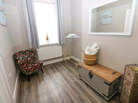 A hallway with a chair, mirror, and storage trunk at Amblers Rest in Amble
