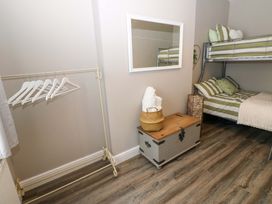 A bedroom with a bunk bed and storage box at Amblers Rest in Amble