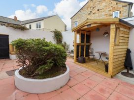 A garden with a wooden shed and a bush at Amblers Rest in Amble