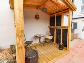 An outdoor seating area with a wooden structure and table at Amblers Rest in Amble