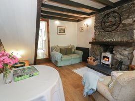 A living room with a sofa and fireplace at Squirrel Cottage in Betws-Y-Coed