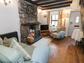 A living room with a fireplace and sofa at Squirrel Cottage in Betws-Y-Coed