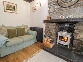 A living room with a sofa and a fireplace at Squirrel Cottage in Betws-Y-Coed