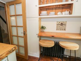 A kitchen with shelves and stools at Squirrel Cottage Betws-Y-Coed