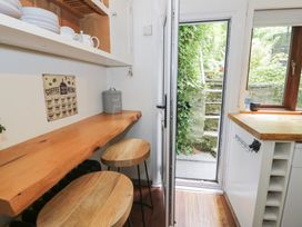 A kitchen with a wooden countertop and stools at Squirrel Cottage in Betws-Y-Coed
