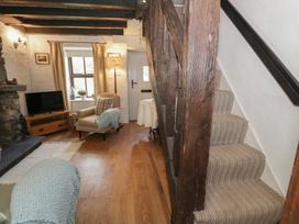 A living room with a television and sofa at Squirrel Cottage in Betws-Y-Coed