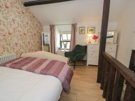 A bedroom with a bed and dresser at Squirrel Cottage in Betws-Y-Coed