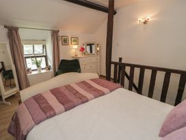 A bedroom with a bed and dresser at Squirrel Cottage Betws-Y-Coed