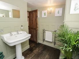 A bathroom with a sink and a mirror at Squirrel Cottage in Betws-Y-Coed