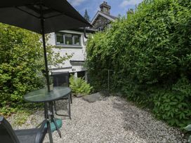 A garden with a table and umbrella at Squirrel Cottage Betws-Y-Coed