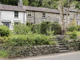A stone cottage with a garden and steps at Squirrel Cottage in Betws-Y-Coed