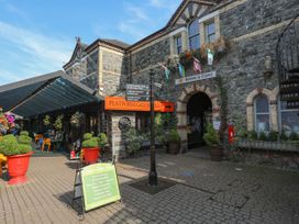 An outdoor area with a coffee shop and signpost at Squirrel Cottage Betws-Y-Coed