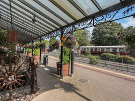 An outdoor platform with planters and flowers at Squirrel Cottage in Betws-Y-Coed