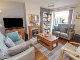 A living room with a television and sofa at Tidal Watch in Seahouses