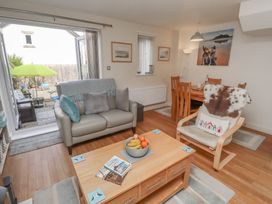 A living room with a sofa and dining area at Tidal Watch in Seahouses
