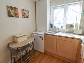 A kitchen with a table and fridge at Tidal Watch in Seahouses