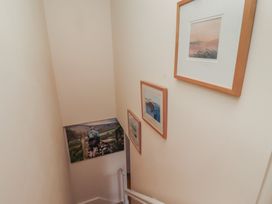 A staircase with paintings on the wall at Tidal Watch Seahouses
