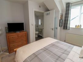 A bedroom with a bed and television at Tidal Watch in Seahouses