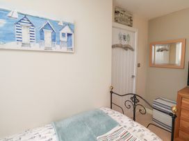 A bedroom with a bed and wall art at Tidal Watch in Seahouses