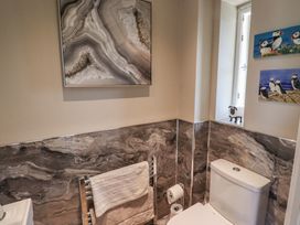 A bathroom featuring a toilet, towel rack, and wall art at Tidal Watch in Seahouses