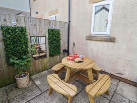 A patio with a wooden table and chairs at Tidal Watch in Seahouses