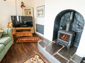 A living room with a television and fireplace at The Old Cornmill in Cemaes Bay