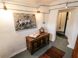 A hallway with a chest and wall art at The Old Cornmill in Cemaes Bay