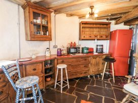A kitchen with wooden cabinets and appliances at The Old Cornmill in Cemaes Bay