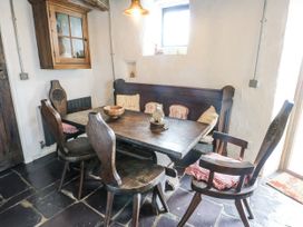 A dining room with a wooden table and chairs at The Old Cornmill Cemaes Bay