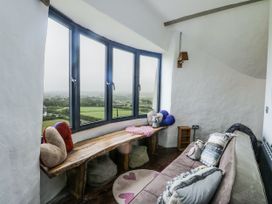 A sitting room with a view and a wooden bench at The Old Cornmill in Cemaes Bay