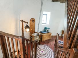 A staircase with a light fixture and wooden chair at The Old Cornmill in Cemaes Bay