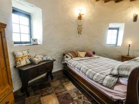 A bedroom with a bed and window at The Old Cornmill in Cemaes Bay