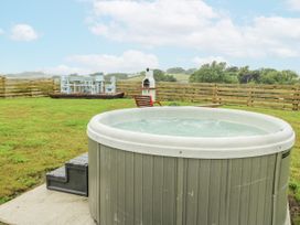 A hot tub and outdoor furniture in a garden at The Old Cornmill in Cemaes Bay