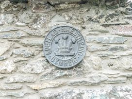 A metal plaque mounted on a stone wall at The Old Cornmill in Cemaes Bay