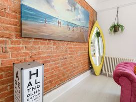 A living room with a painting on a brick wall at The Beach Condo in Weymouth