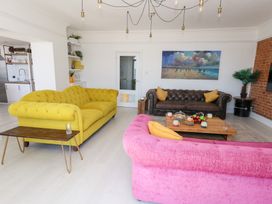 A living room with colorful sofas and a coffee table at The Beach Condo in Weymouth