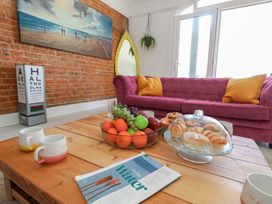 A living room with a sofa, table, and fruit bowl at The Beach Condo in Weymouth